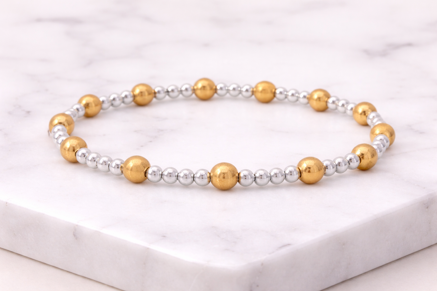 Elastic bracelet with 3mm sterling silver ball, 5mm 14KT gold filled ball, 7″ in length